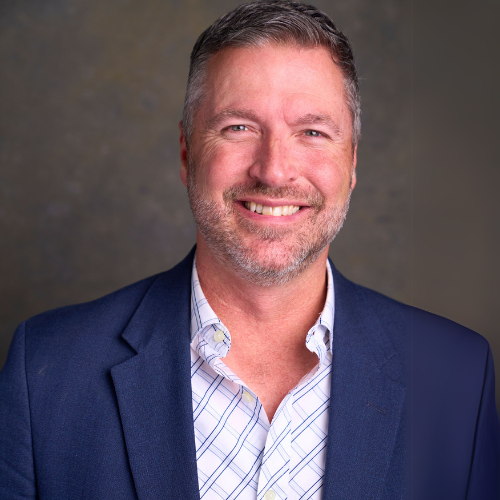 A man and a woman are sitting on a dock overlooking a lake.