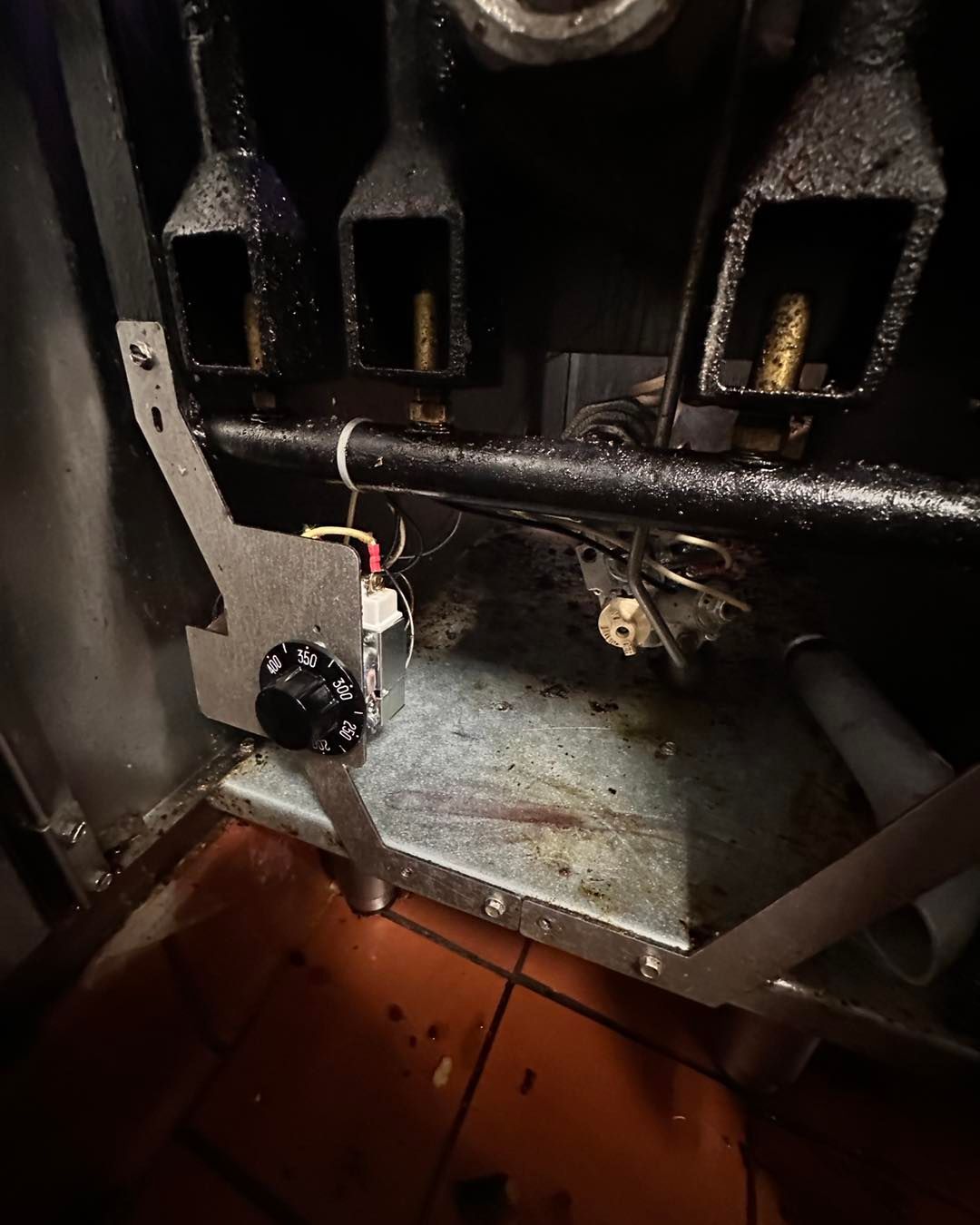 A close up of a stove with a thermostat on it.