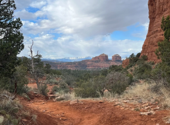 A dirt road in the desert with mountains in the background.