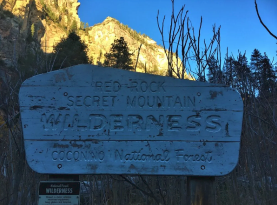 A sign that says secret mountain wilderness on it