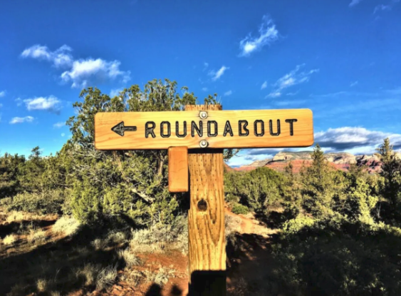 A wooden sign that says roundabout on it