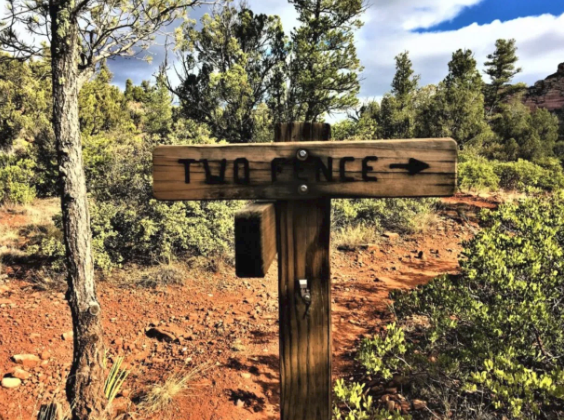 A wooden sign that says two fence on it