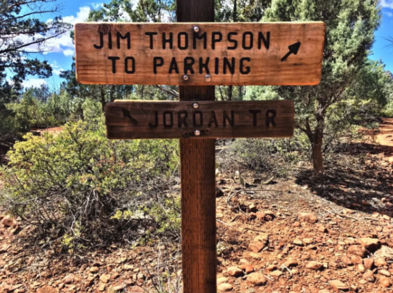 A wooden sign that says jim thompson to parking and jordan tr