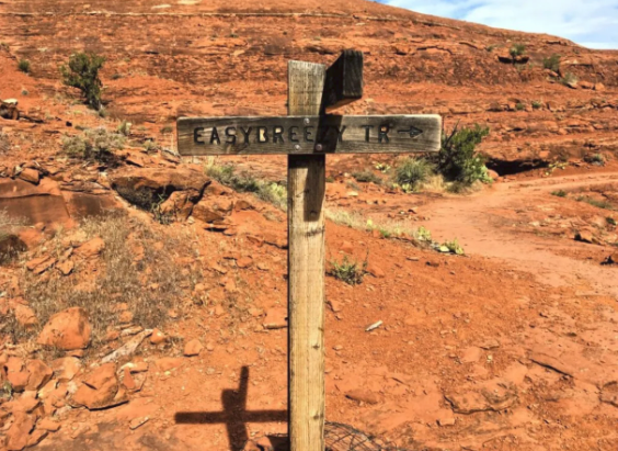 A wooden sign in the desert says easy creek trail