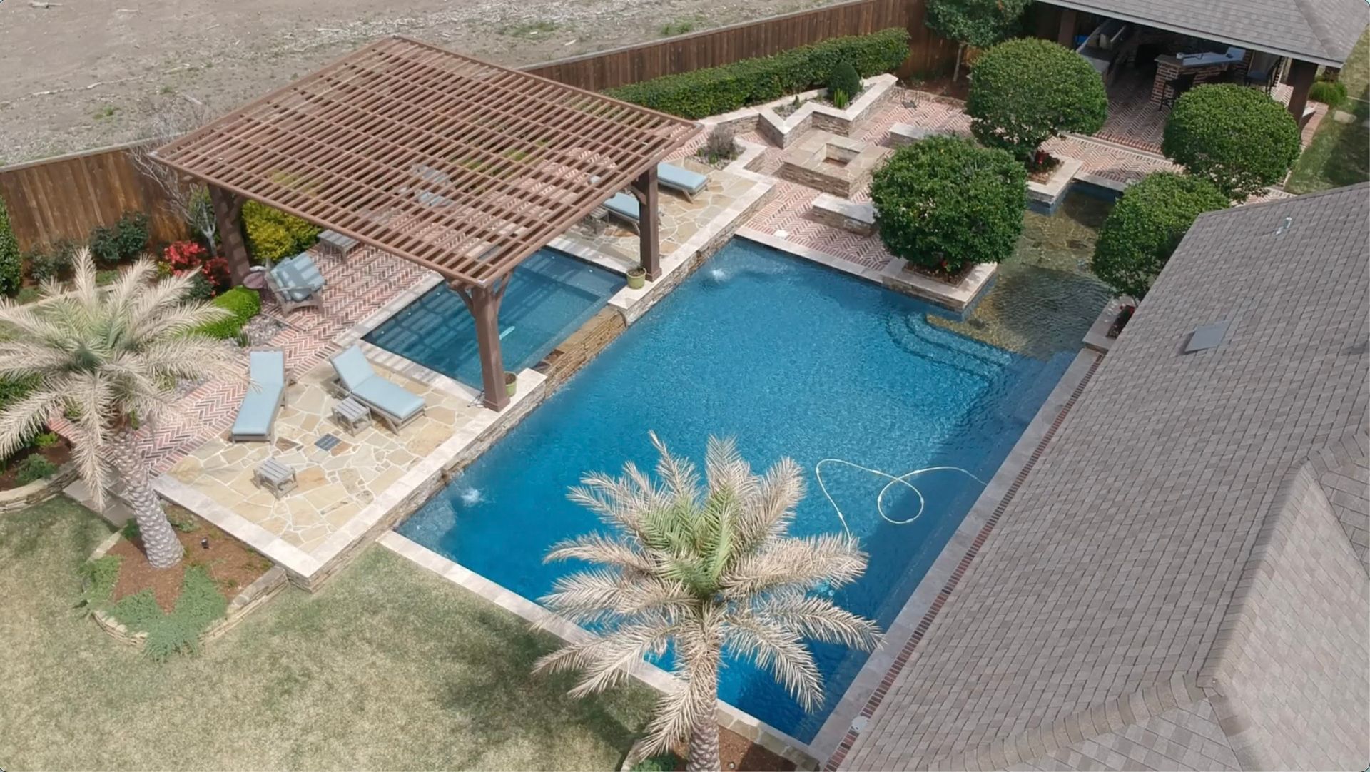 An aerial view of a large swimming pool in a backyard.