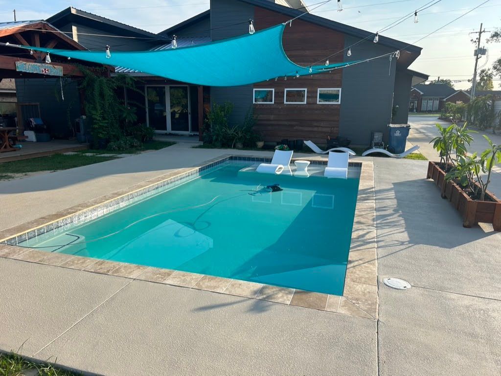 A large swimming pool in front of a house with a blue canopy over it