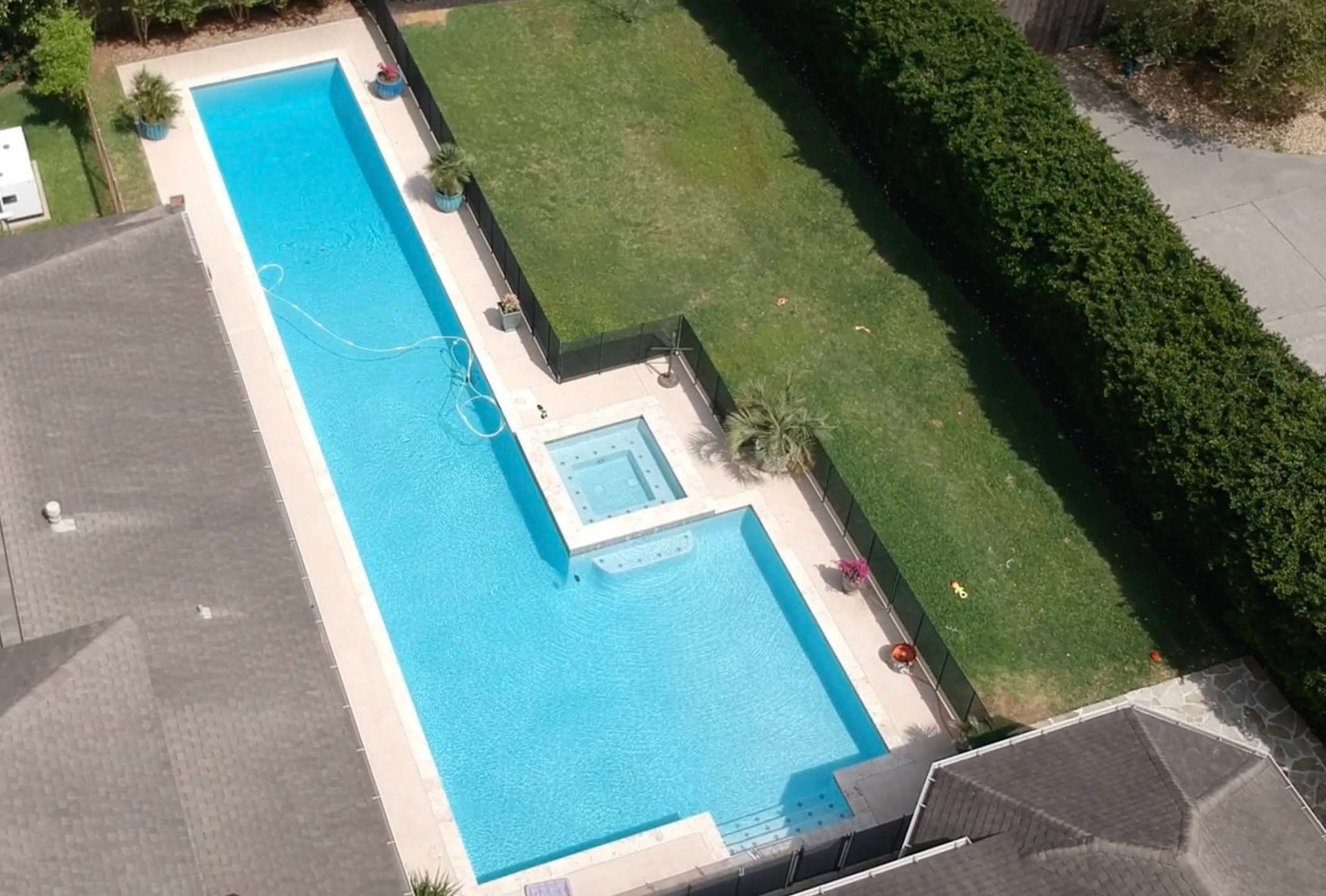An aerial view of a large swimming pool in a backyard
