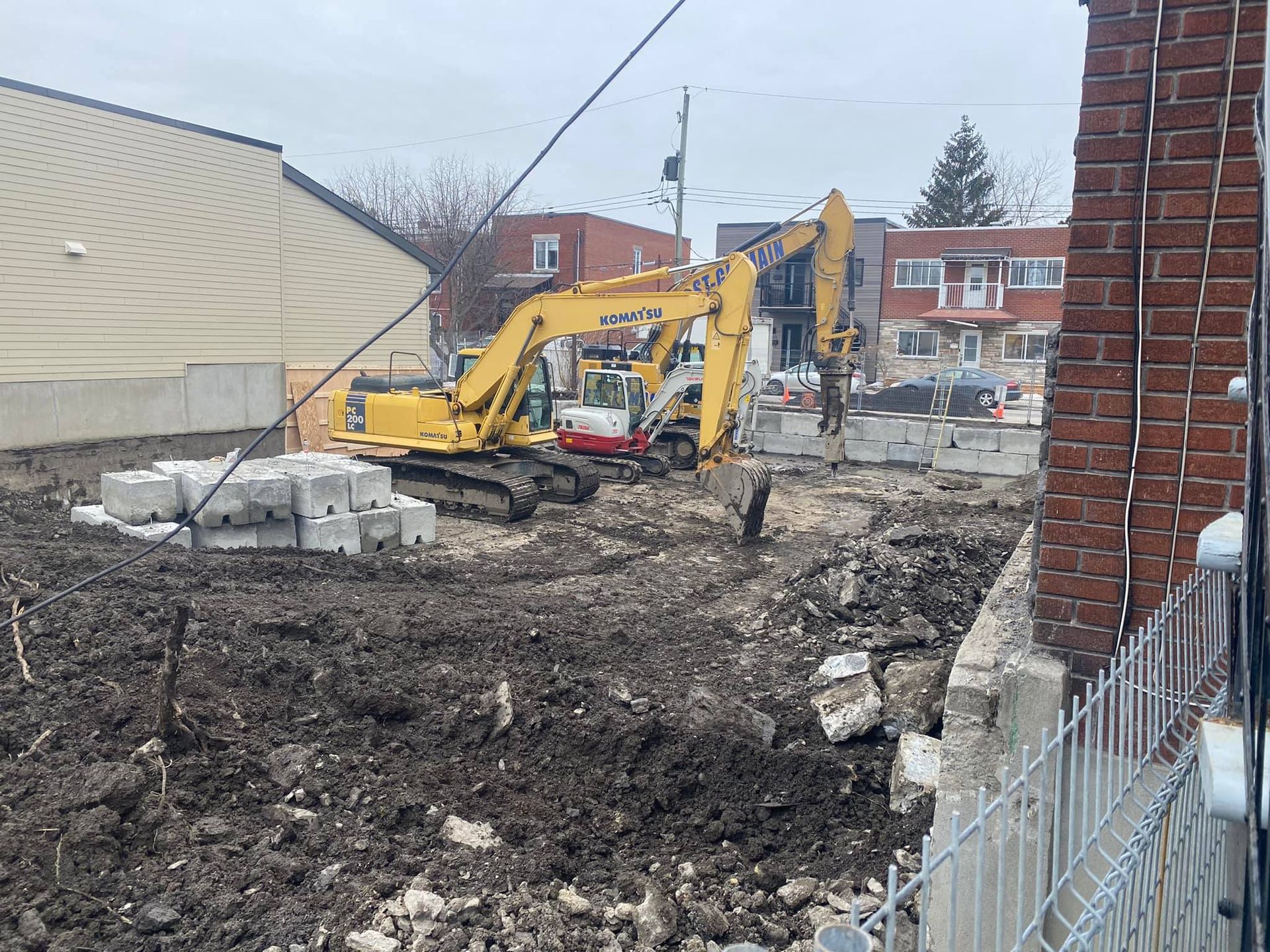 Une grande excavatrice jaune travaille sur un chantier de construction.