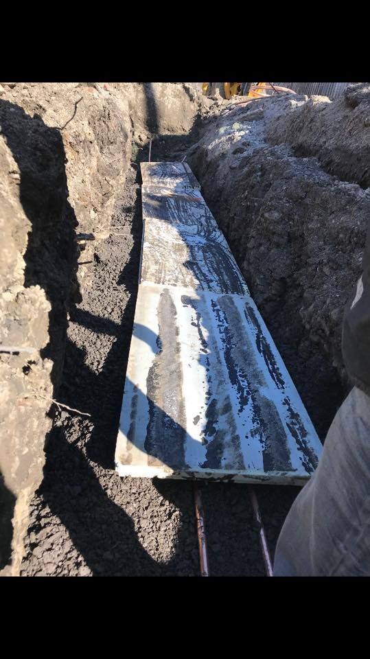 Un morceau de métal est posé sur un tas de terre.