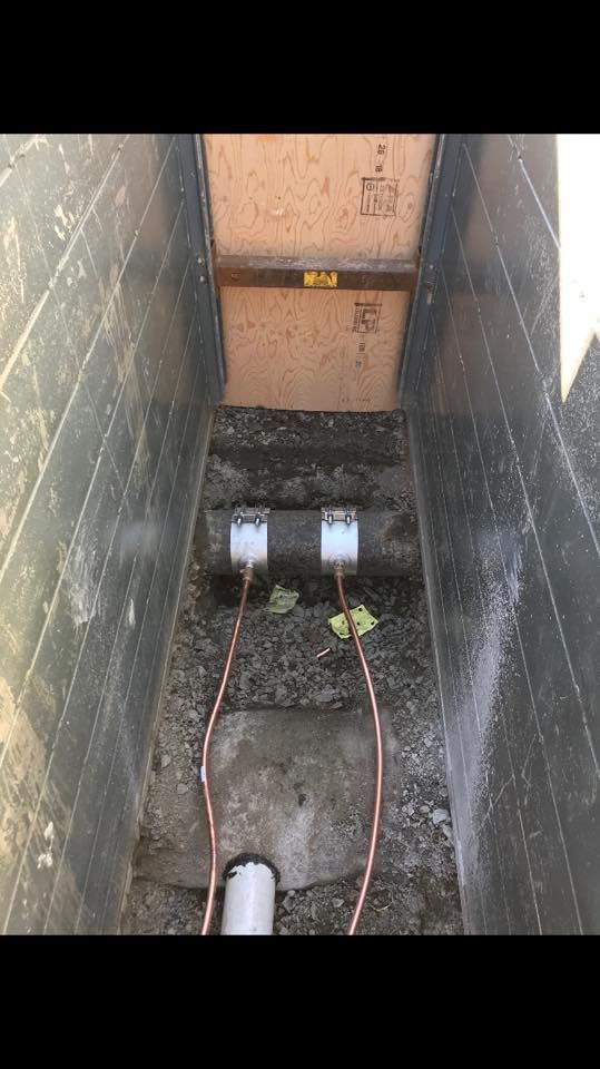 Deux tuyaux sont reliés l'un à l'autre dans un trou dans le sol.