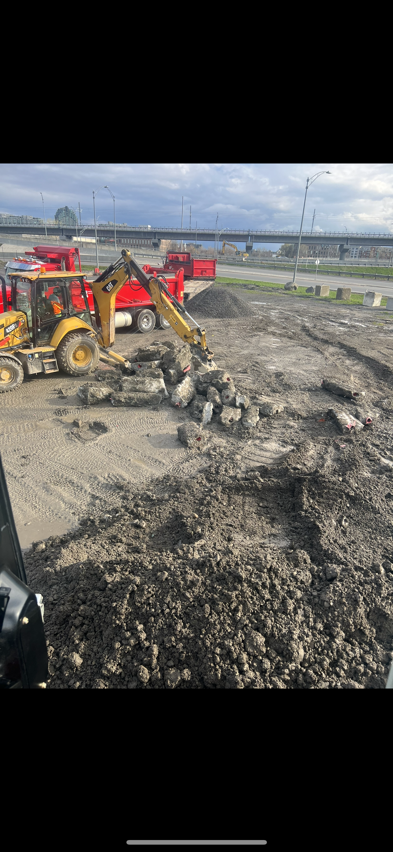 Un bulldozer creuse un trou dans un champ de terre.