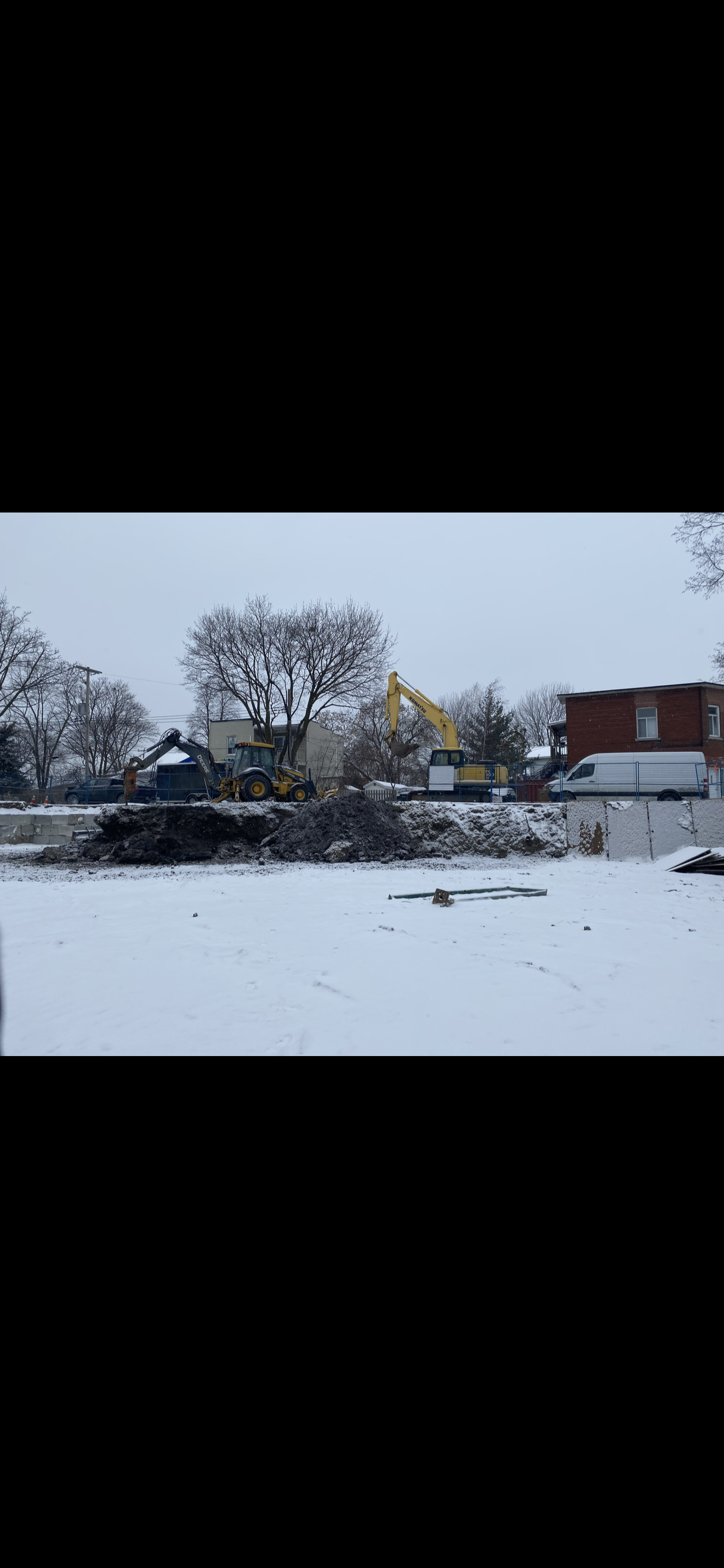 Il y a beaucoup de neige au sol et des arbres en arrière-plan.