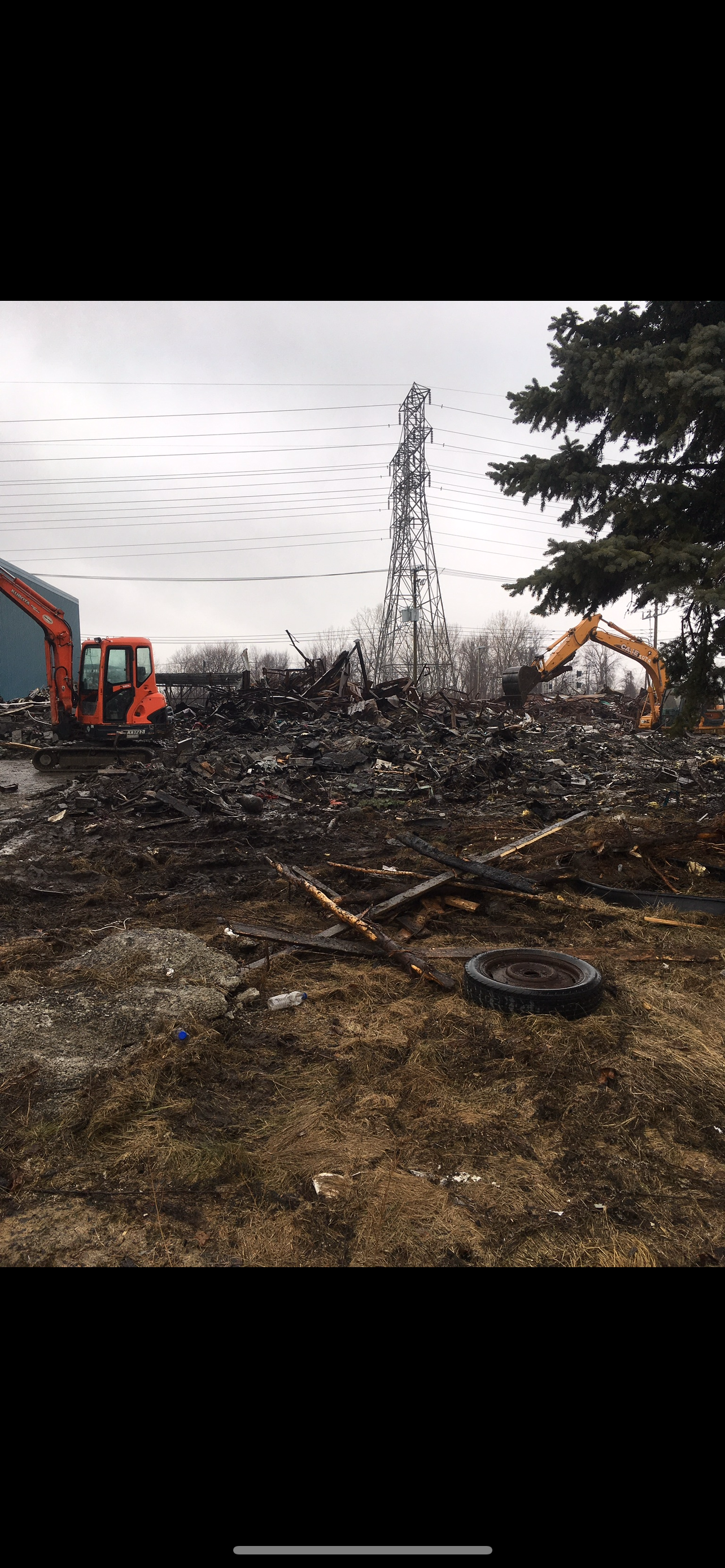 Un bulldozer déplace un tas de ferraille dans un champ.