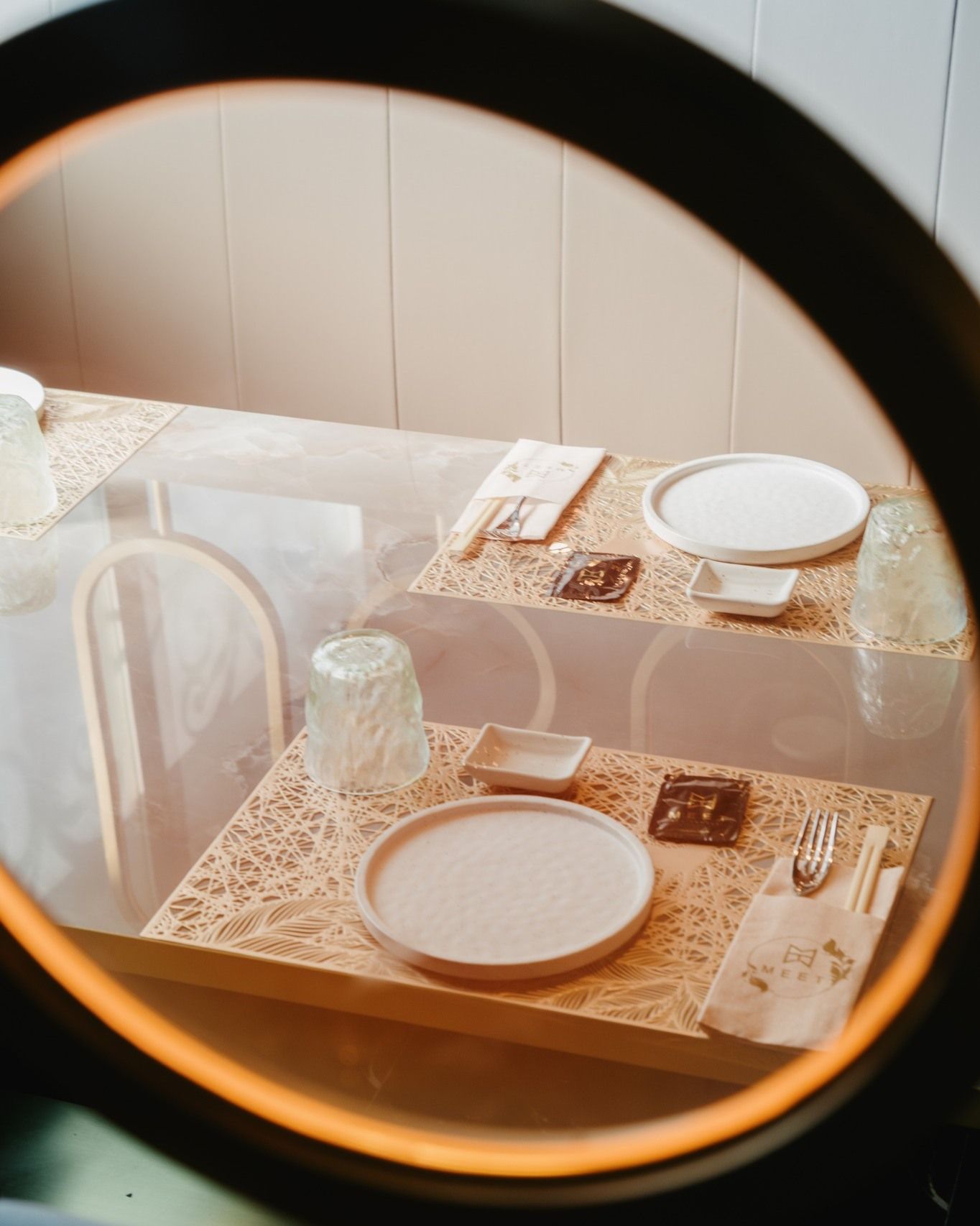 Un tavolo con piatti e bicchieri sopra è visto attraverso una lente di ingrandimento