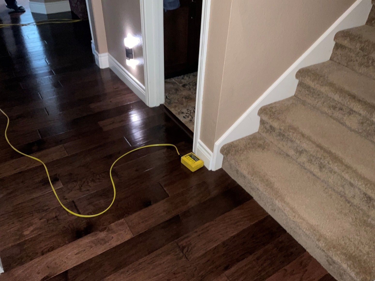 Ziplevel altimeter placed on a wooden floor near carpeted stairs