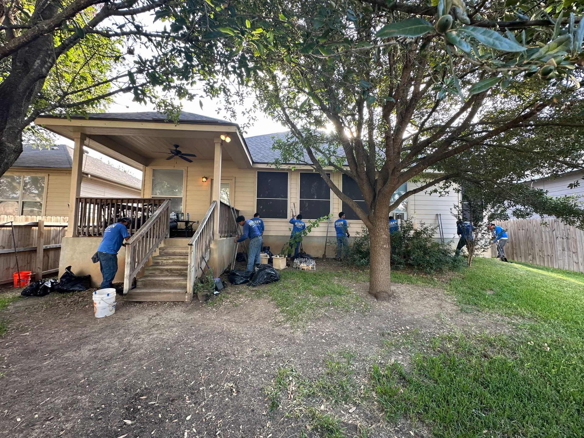 A group of people are standing in front of a house.