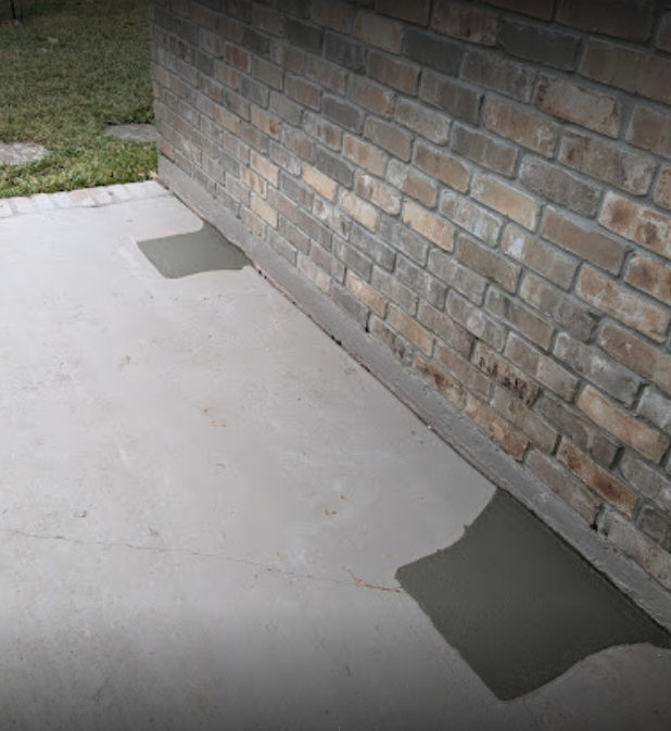 A brick wall with a concrete sidewalk in front of it