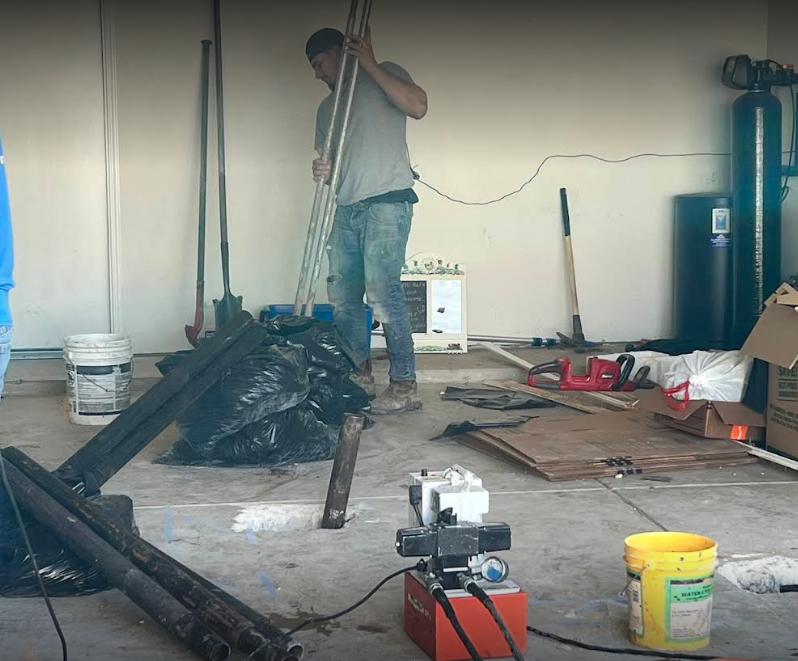 A man is standing in a garage holding a pole