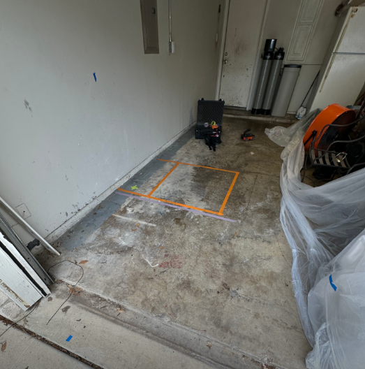 A room with a concrete floor and a white wall.