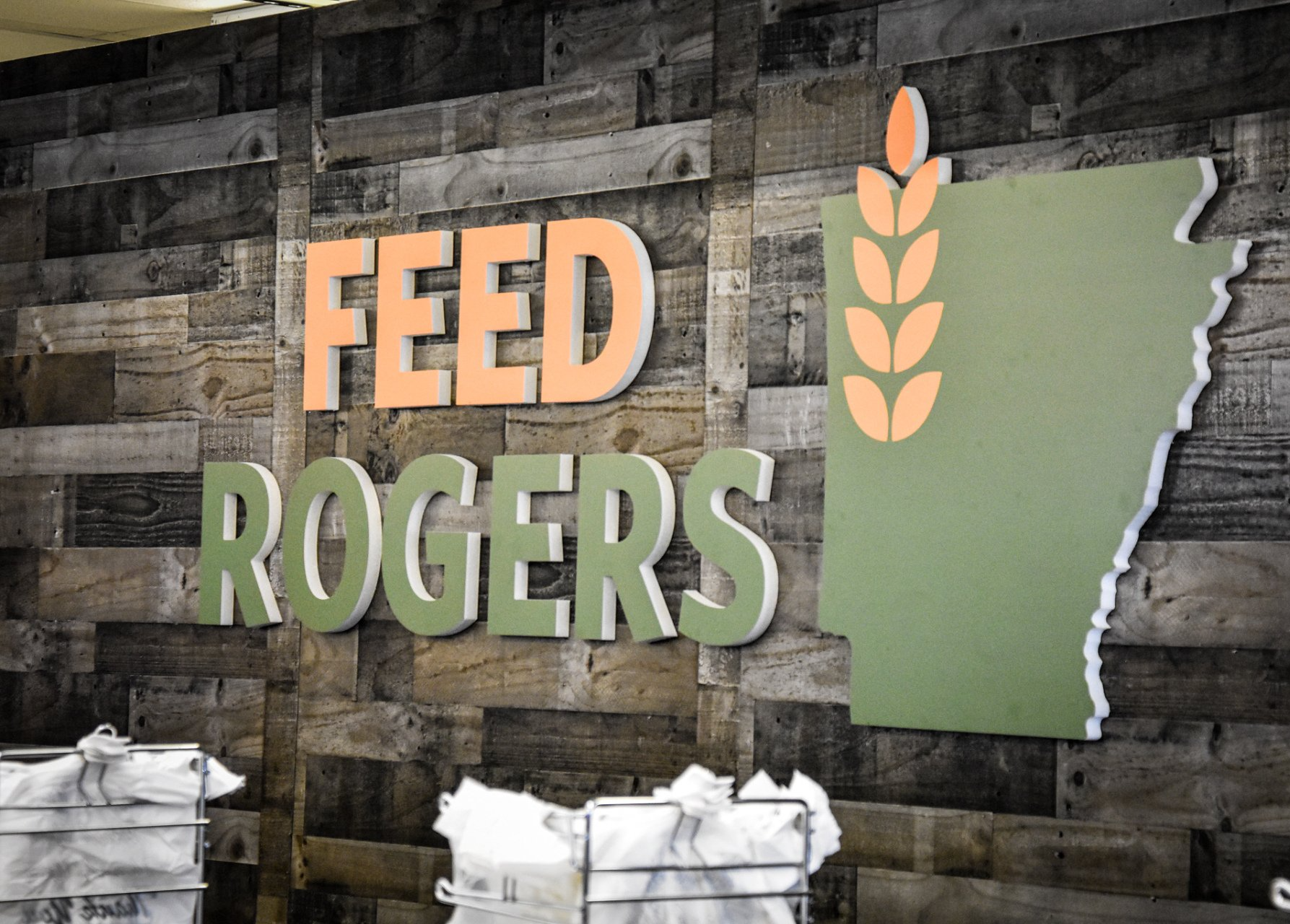 A sign that says feed rogers on a wooden wall