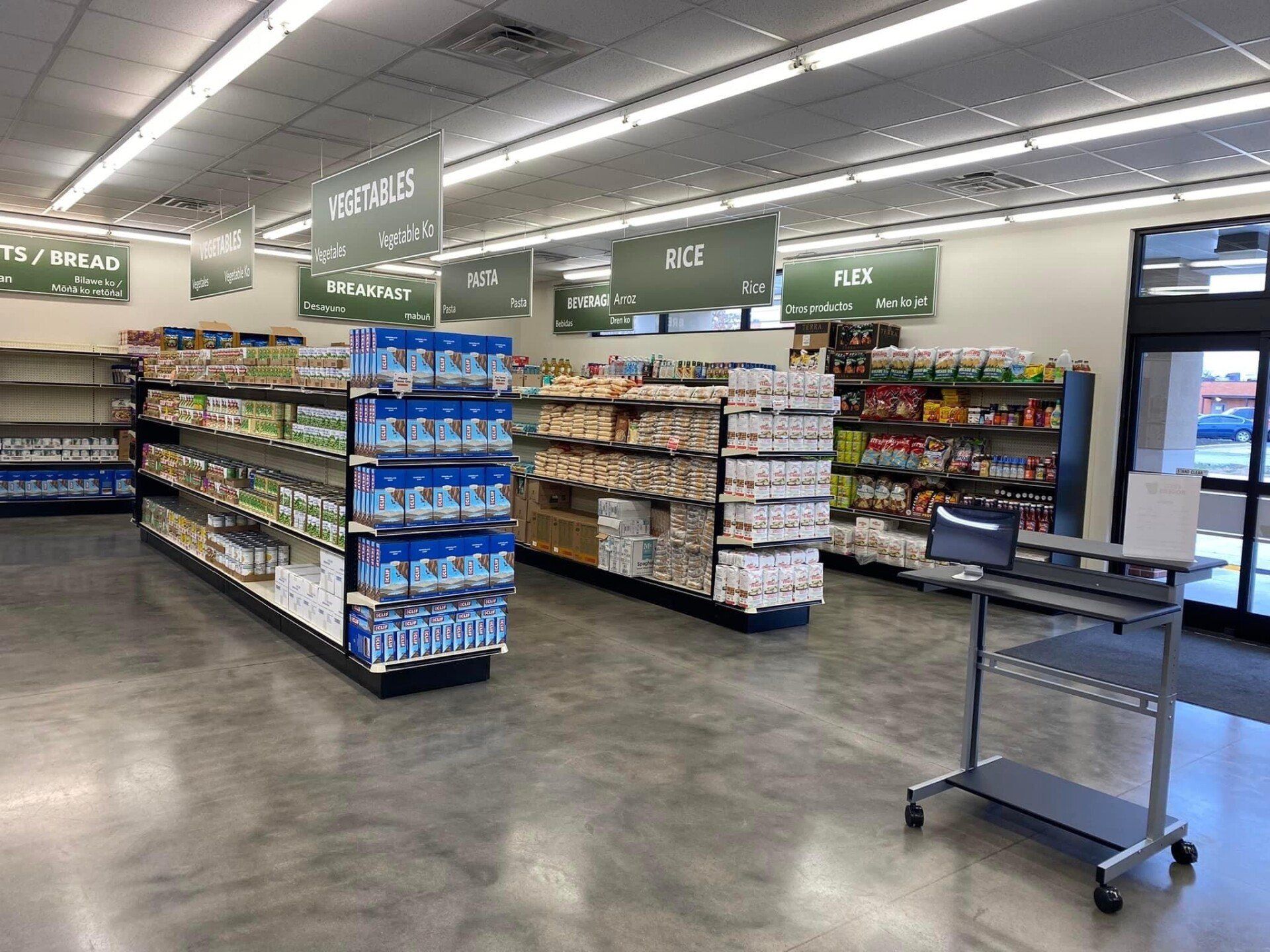 The inside of a grocery store with lots of shelves and a desk.