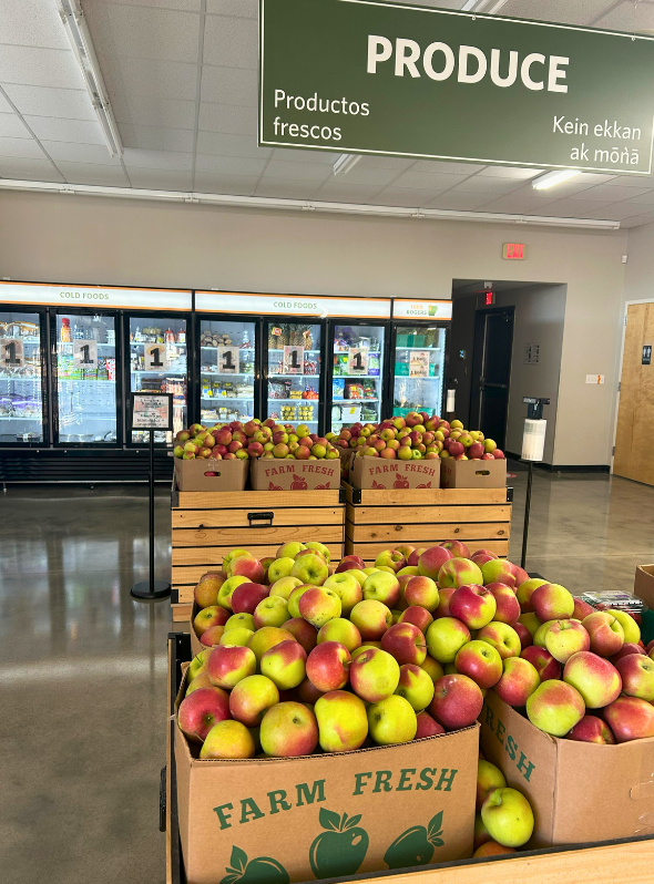 The inside of a grocery store with lots of shelves and a desk.