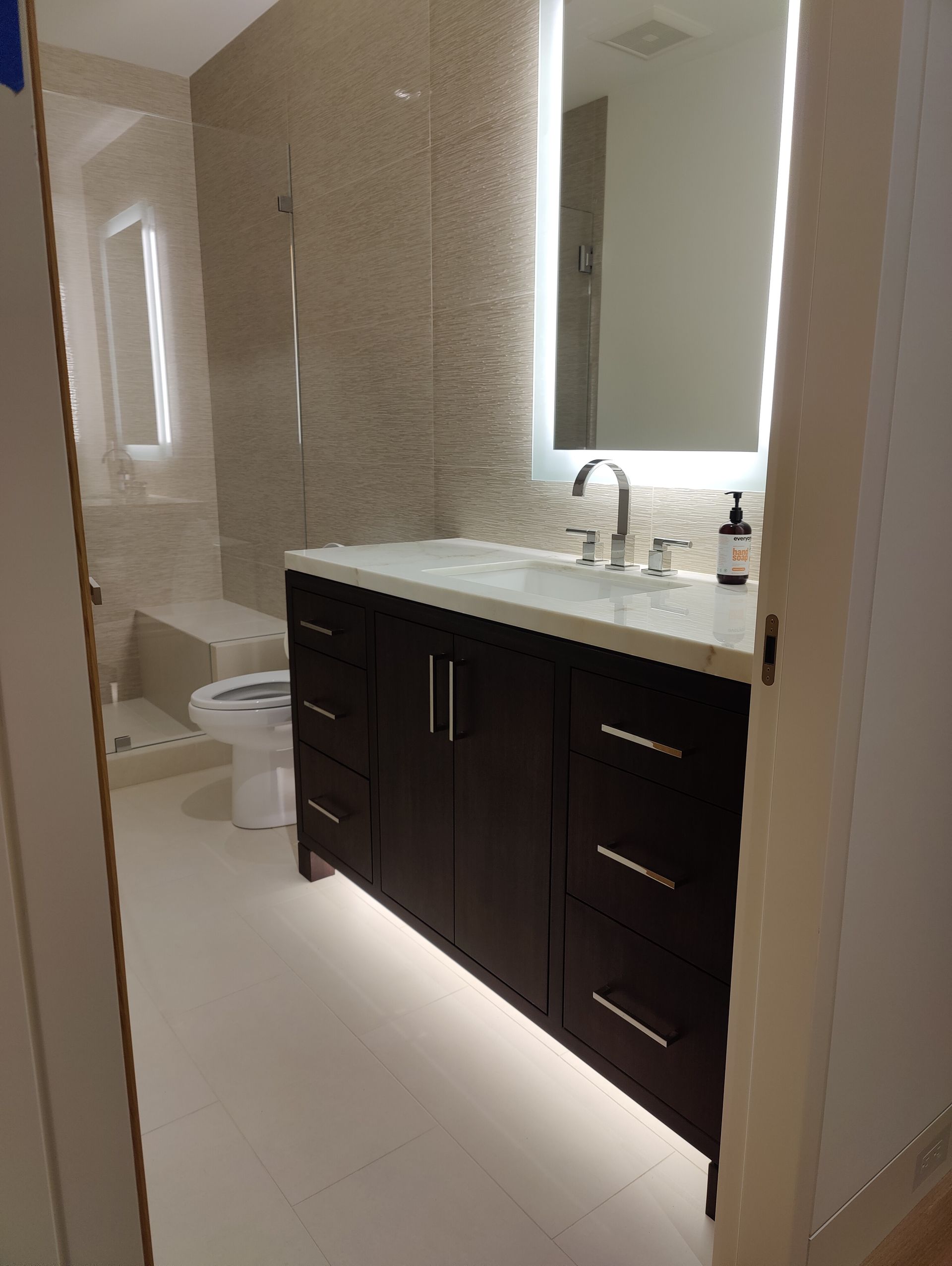 Wooden double vanity with two mirrors, silver faucets, and storage cabinets