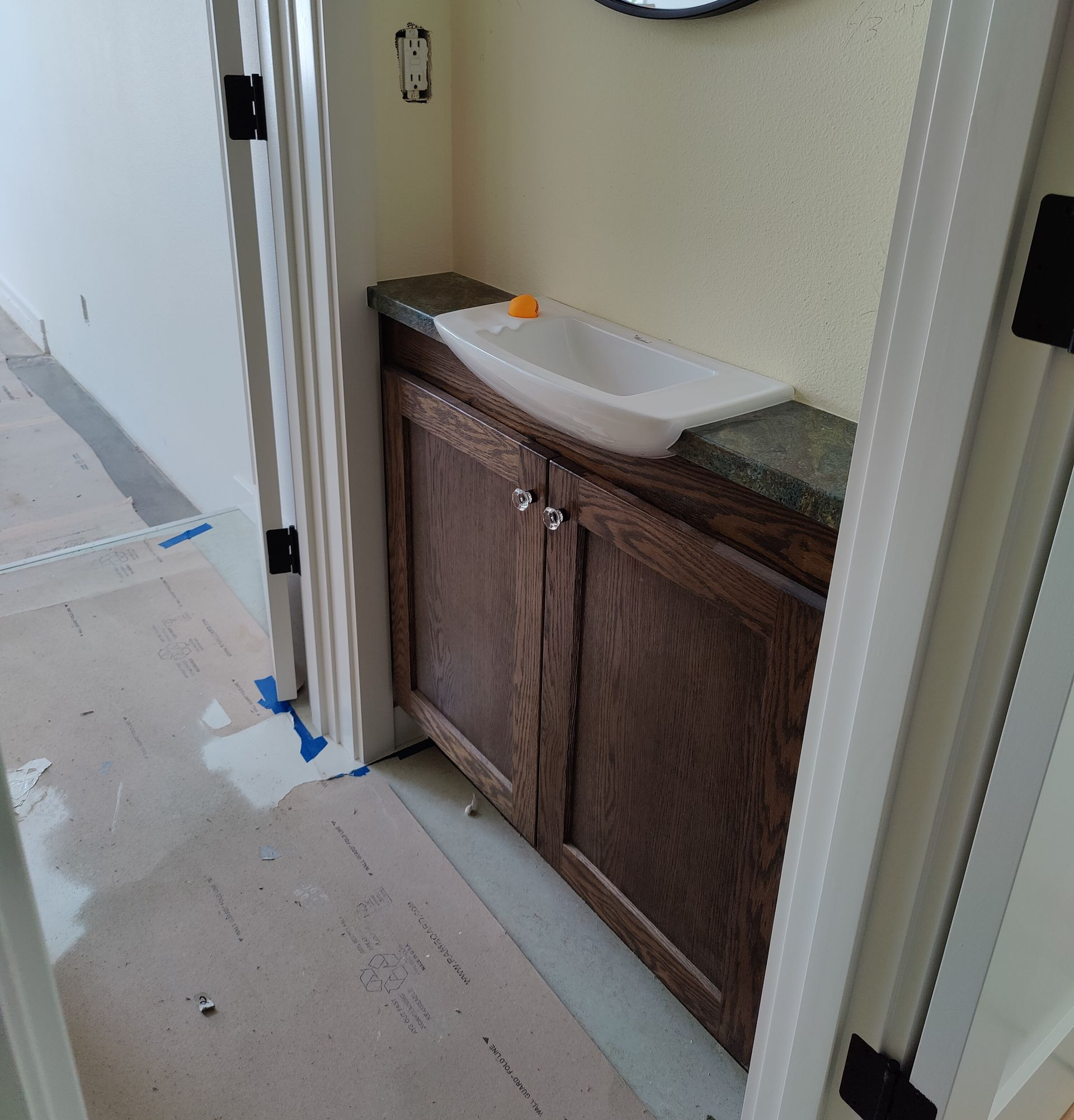 Wooden storage cabinets under a staircase with white steps and railing