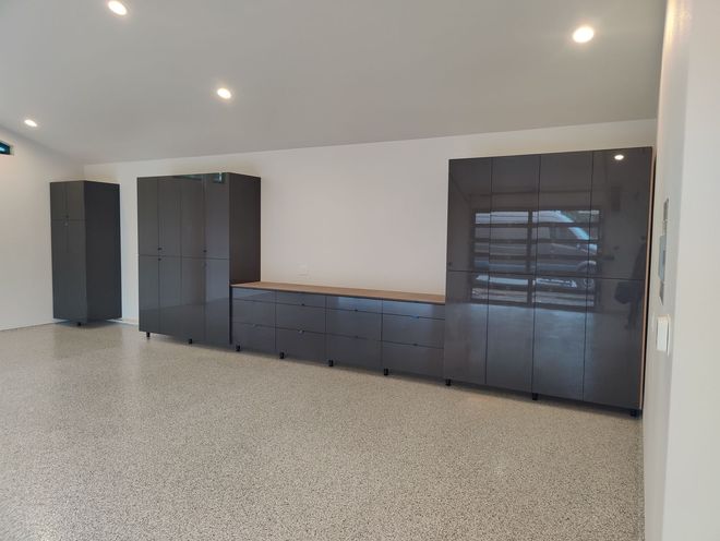 Modern bathroom with a wooden accent wall, and large round mirrors