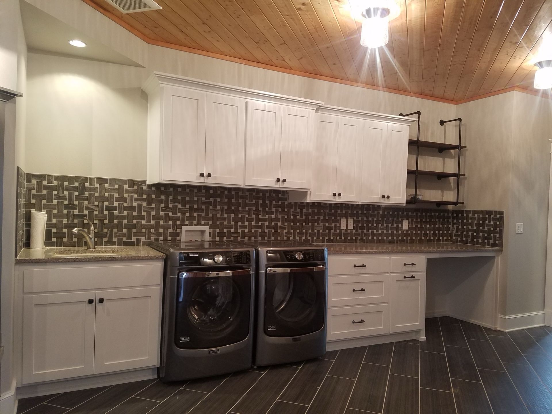Laundry room with washing machine, cabinets, shelves, and plants