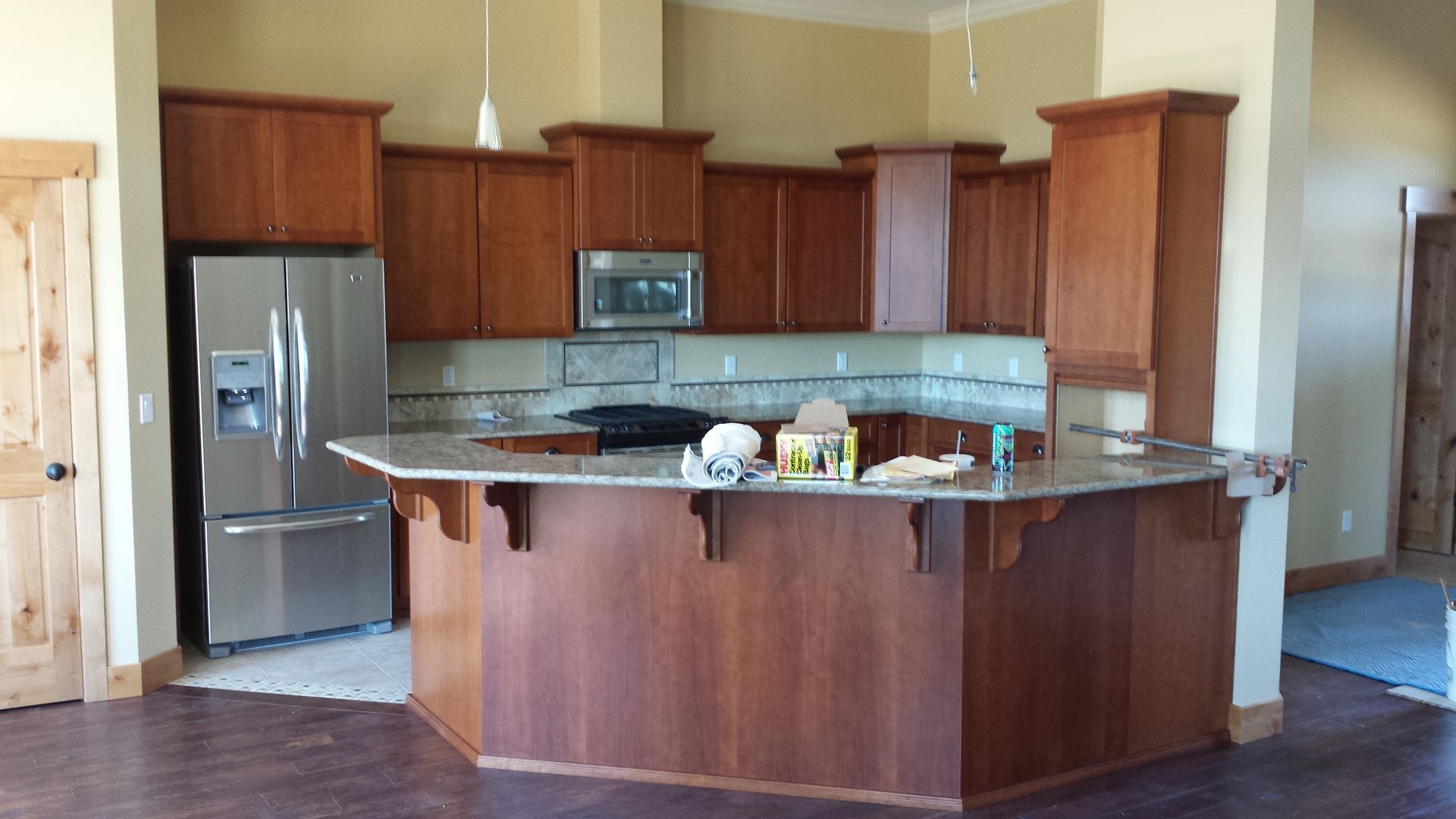 Light wood kitchen with cabinets, appliances, and tiled backsplash