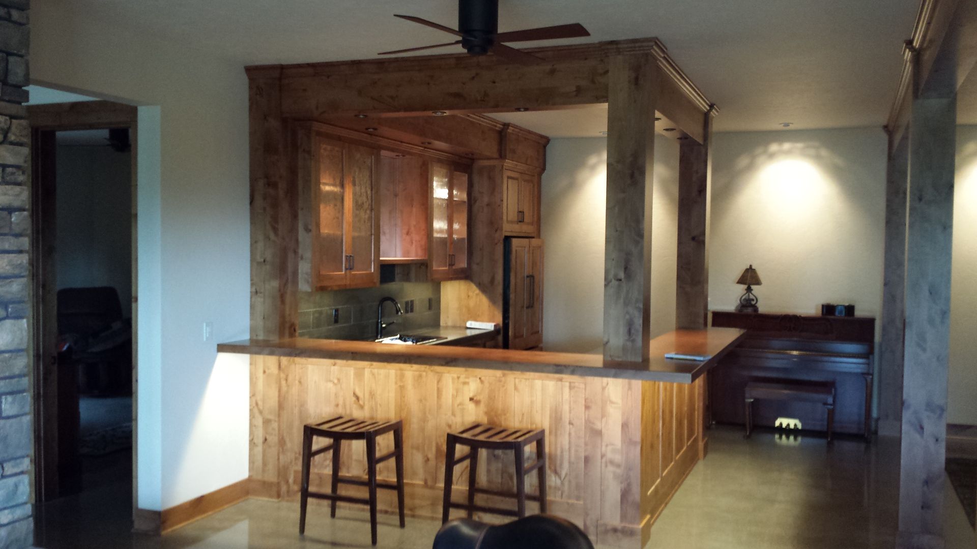 Large black television mounted on a light wood panel wall