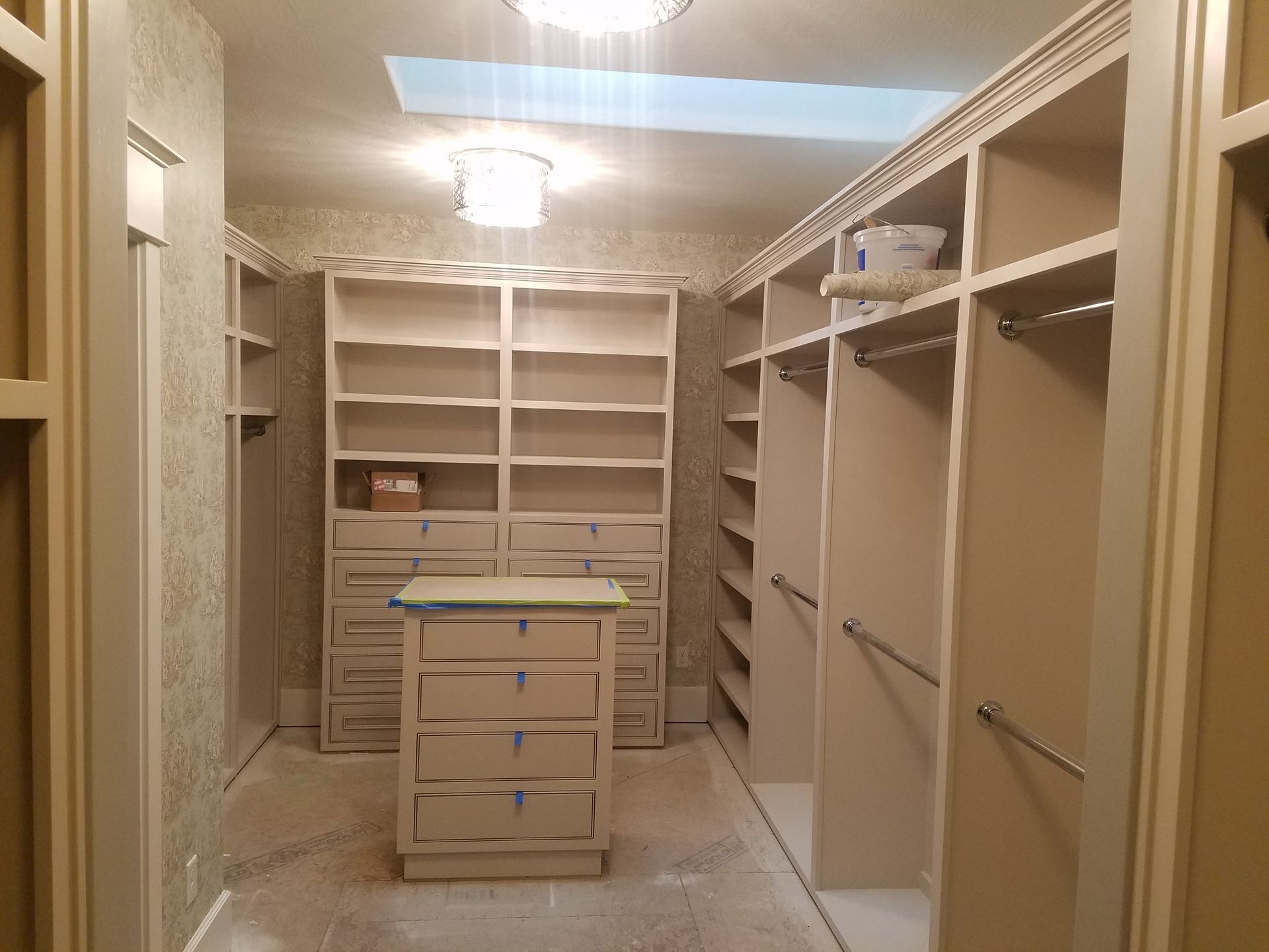 Two men installing kitchen cabinets in a room