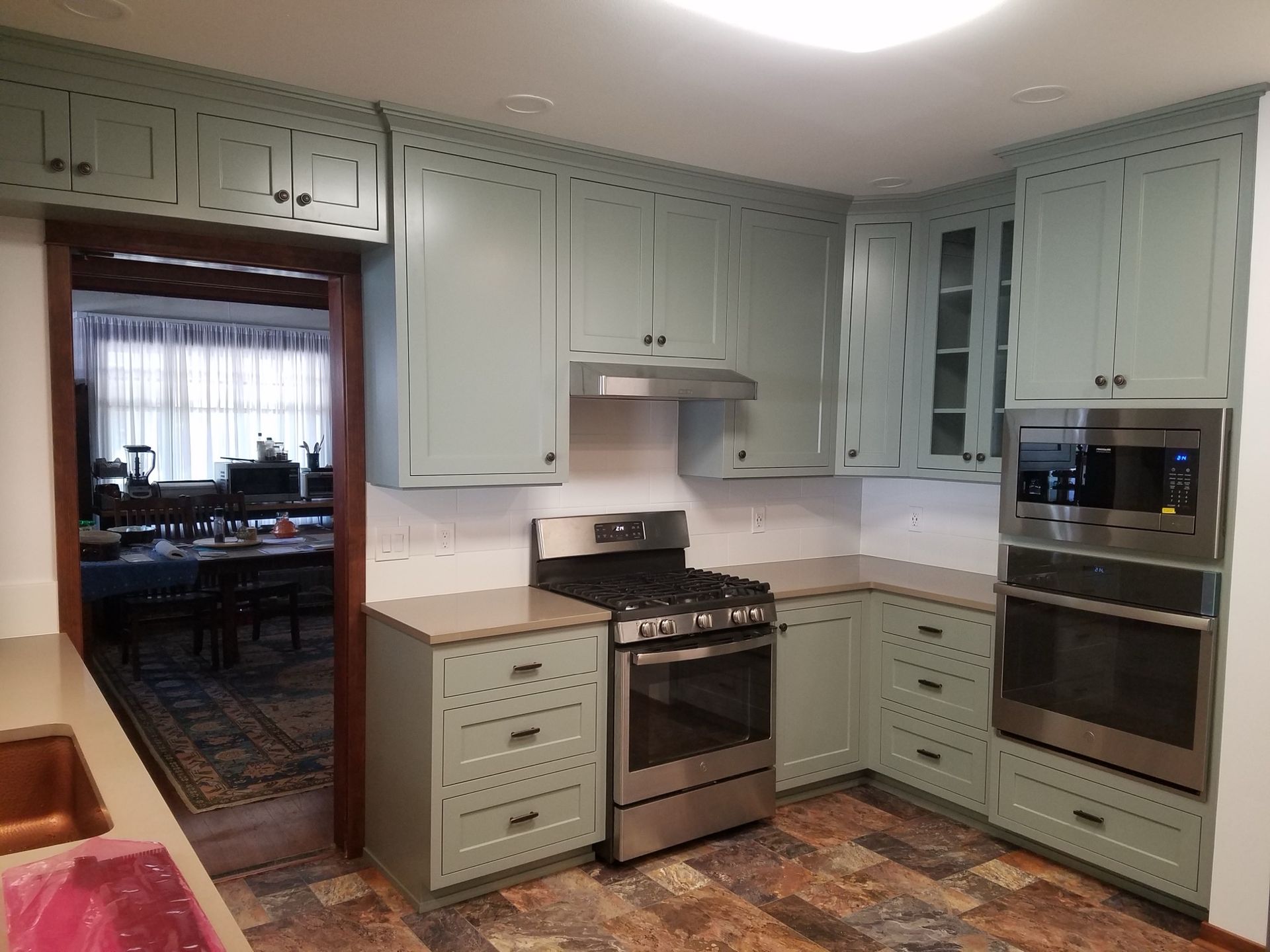 Wooden kitchen cabinets with built-in oven and textured backsplash