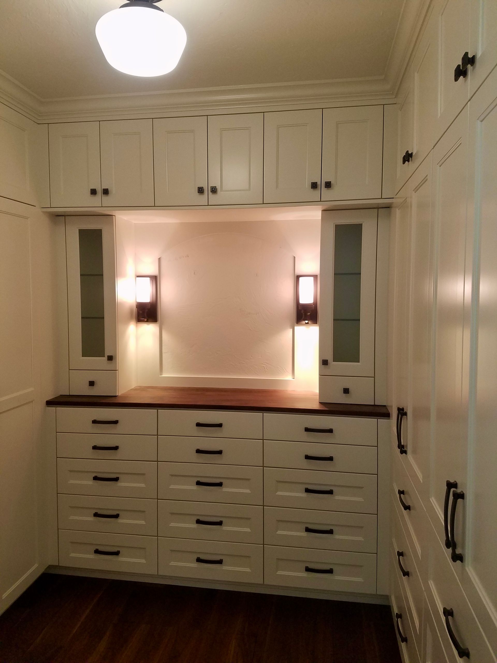 Wooden walk-in closet with drawers and hanging clothes