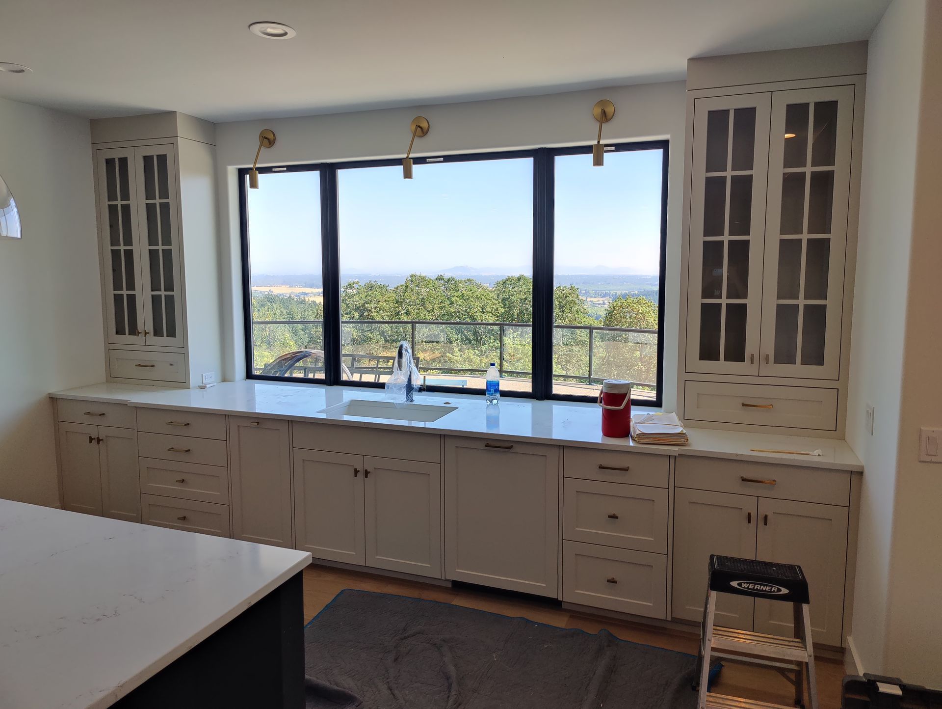 Built-in cabinet with sliding doors and illuminated shelves, featuring Beige wood and a gray base