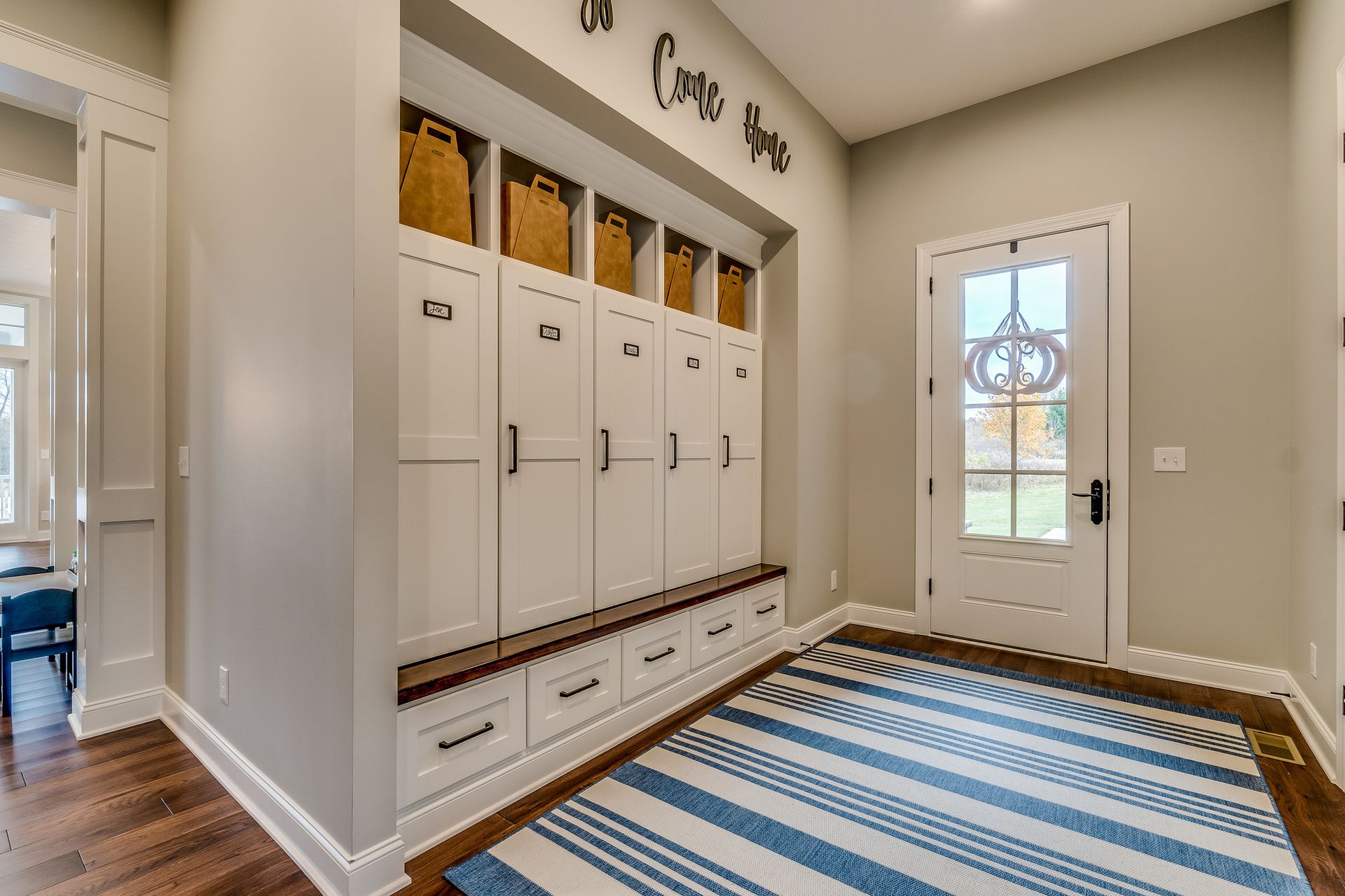 Entryway with white storage lockers and a wooden bench