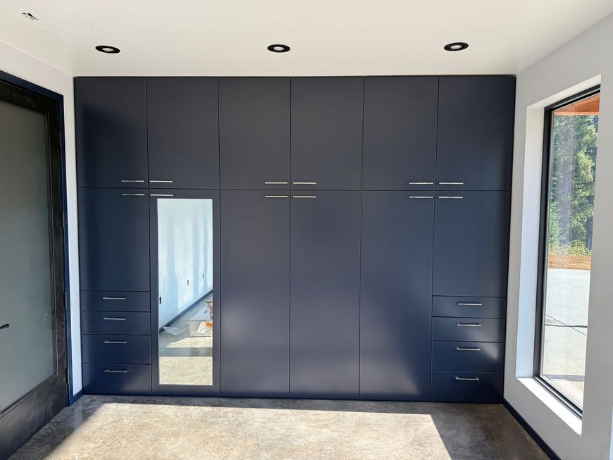 Wooden dining room with round table, chairs, and large windows overlooking a field