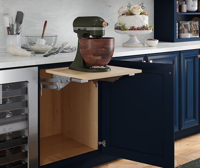 Dark blue kitchen cabinet with pull-out shelf holding a stand mixer. A wine fridge is visible. Dark blue kitchen cabinet with pull-out shelf holding a stand mixer. A wine fridge is visible.