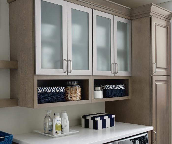 Laundry room with white countertop, cabinets with frosted glass doors, and storage baskets. Laundry room with white countertop, cabinets with frosted glass doors, and storage baskets.