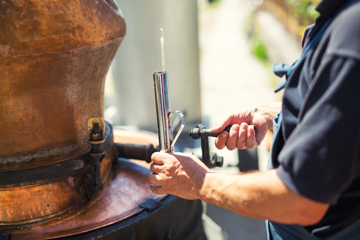 Man working on still at distillery 