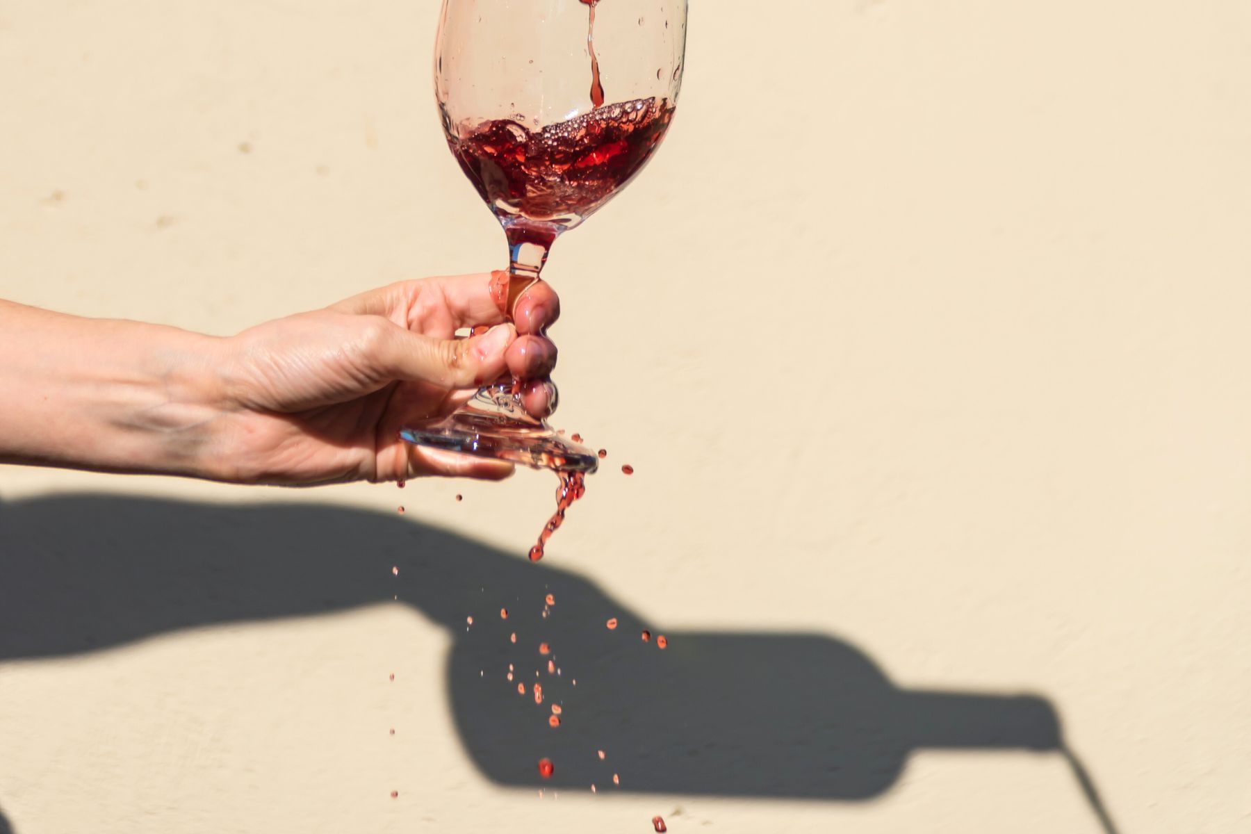 A person is pouring red wine into a glass.