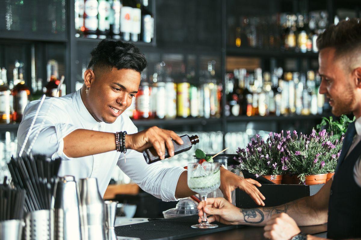 male bartender making cocktail for customer