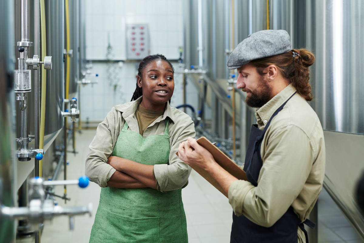 two brewery workers discussing production schedules