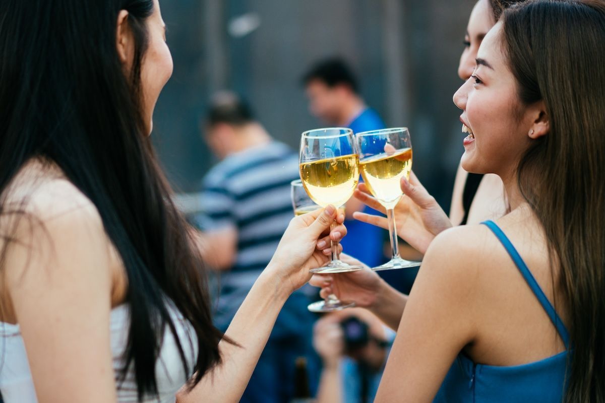 Group of young Asian women enjoying wine
