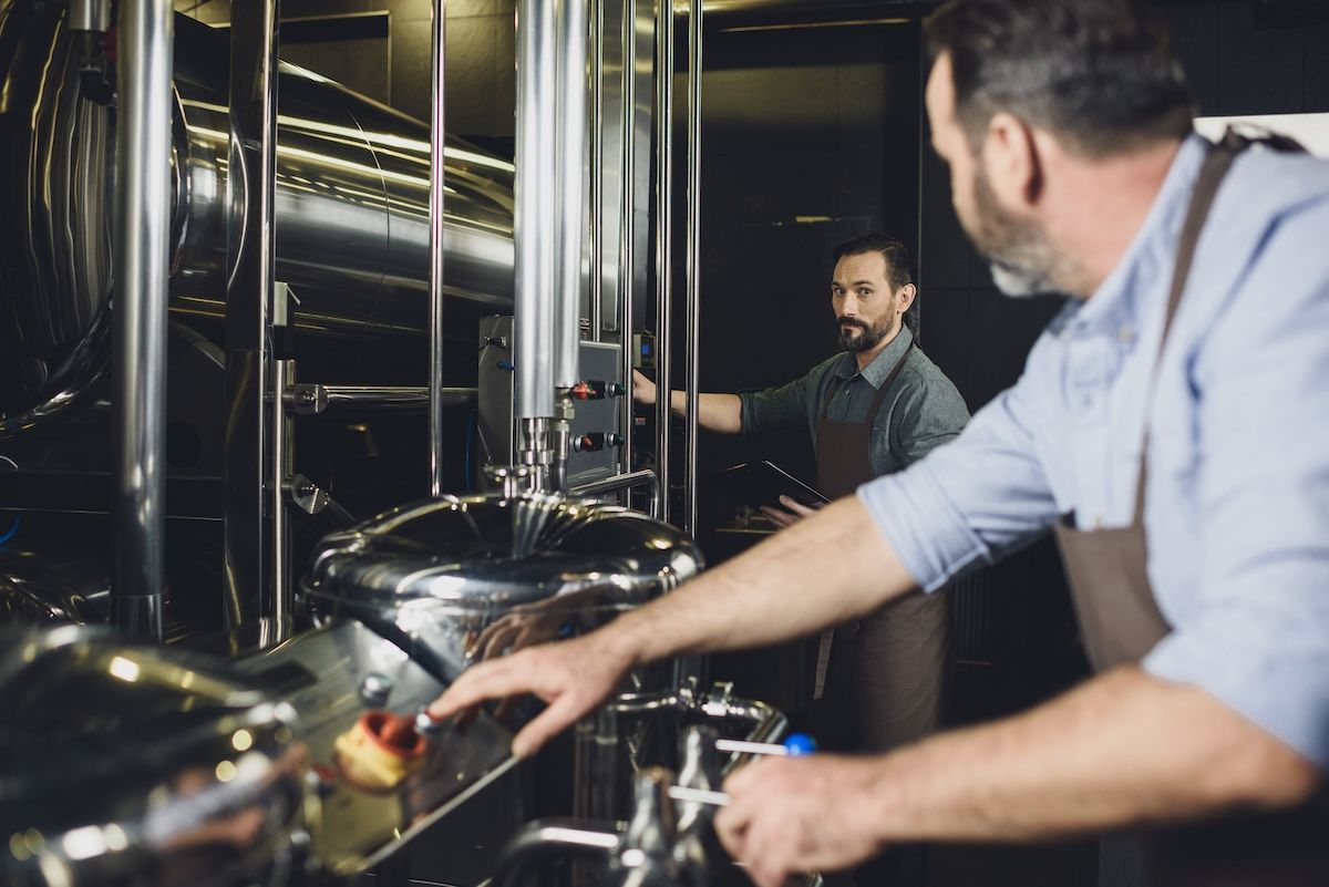 Male brewers working together to create a brewstillery