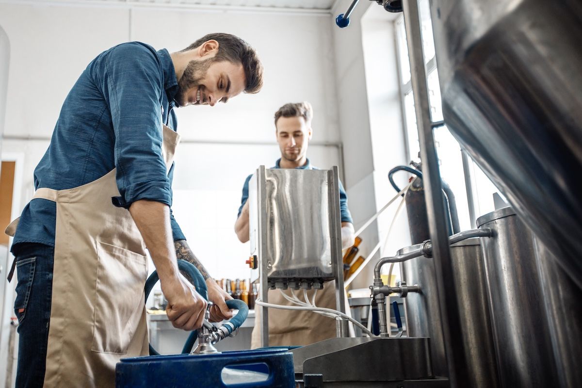 Brewery employees working together on a small batch of beer
