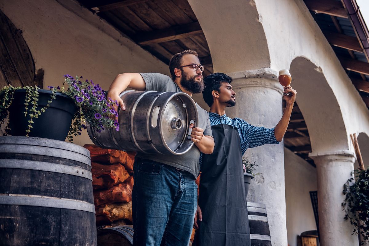 two brewers outside checking beer batch