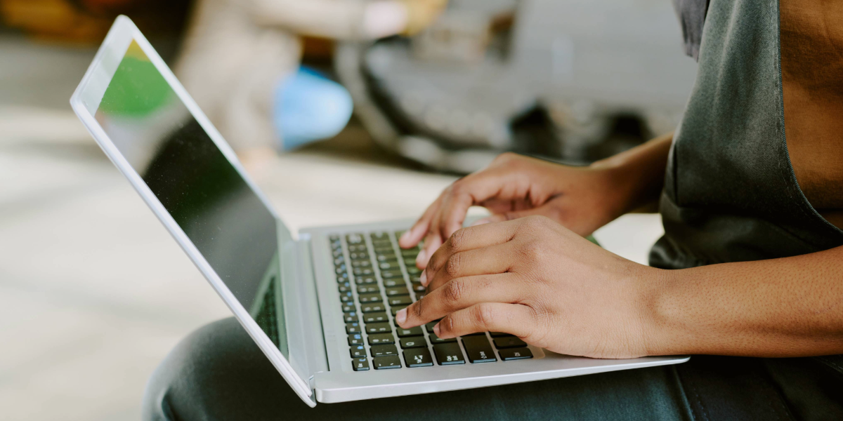 Unrecognizable black woman working on laptop on brewery floor 