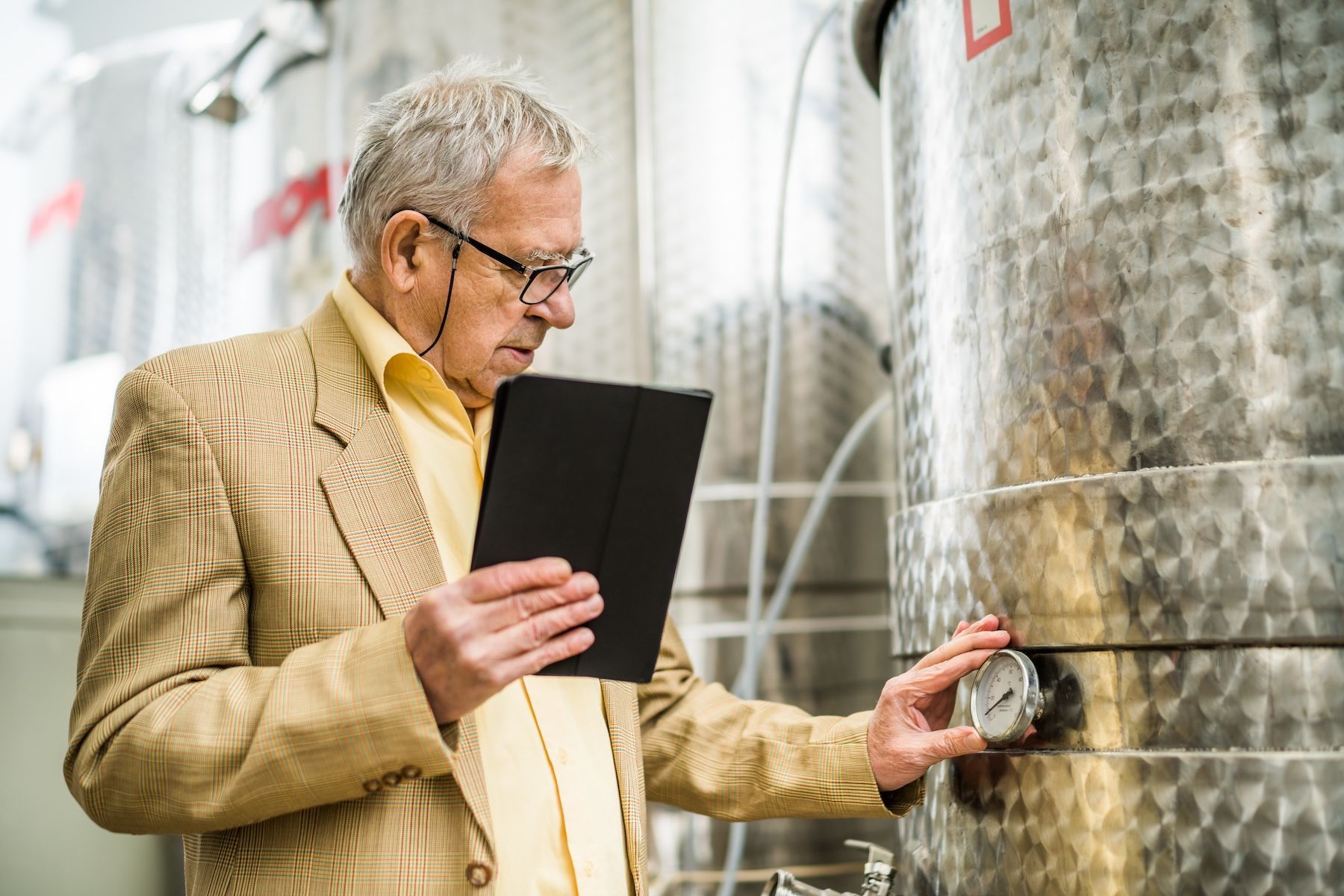 Winemaker entering tank measurements on a tablet 